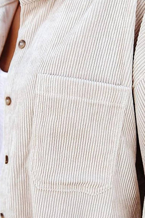 Close-up of beige sleek suede oversized button-down shirt with textured fabric and front pocket detail