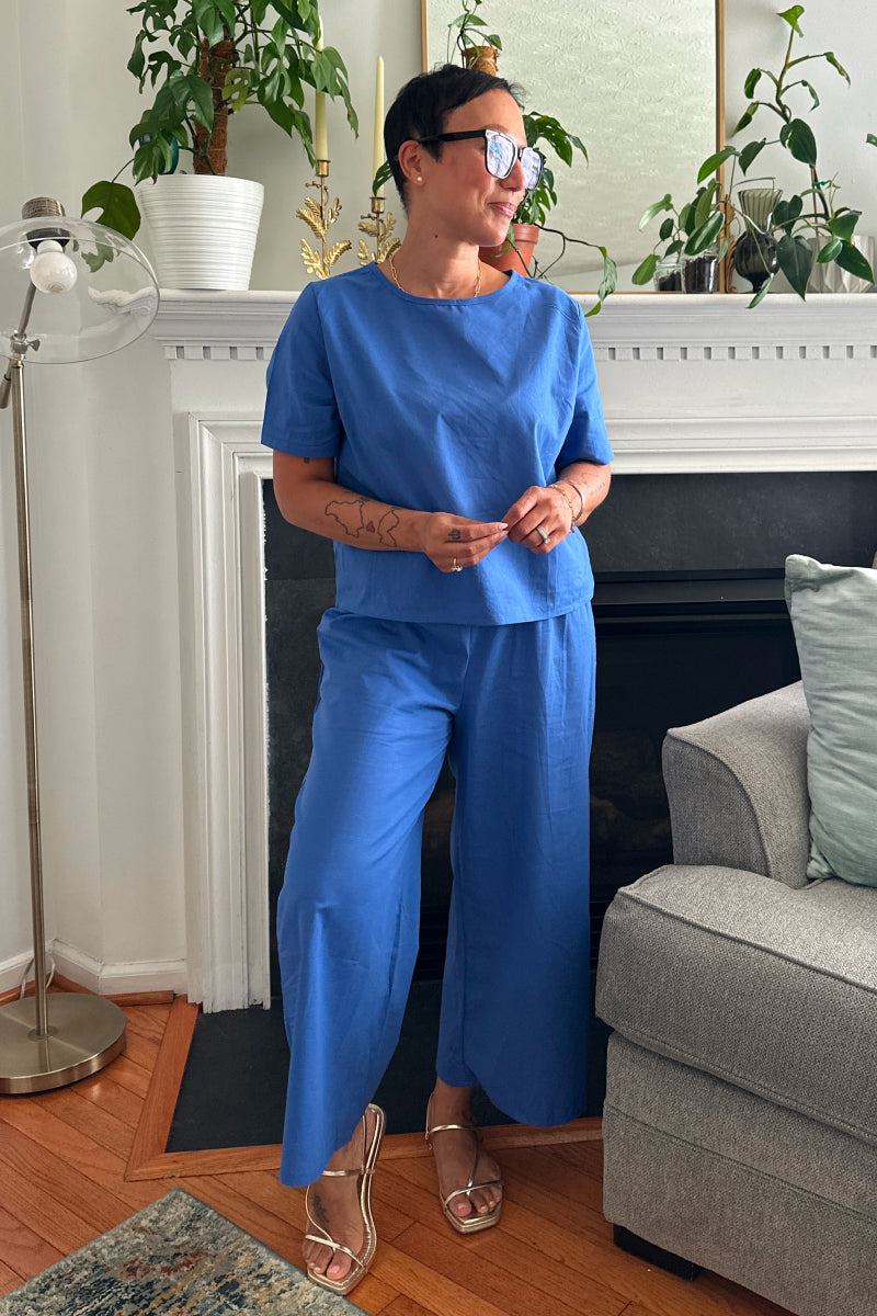 Woman wearing blue loose fit co-ord set with short sleeves and wide-leg pants indoors.