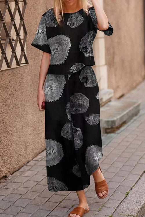 woman wearing black loose fit co-ord set with gray circular patterns and wide-leg pants on street