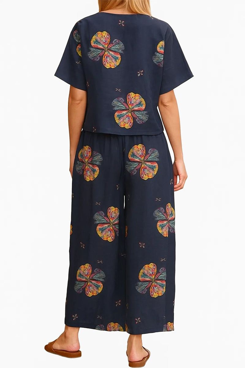 Back view of navy blue loose fit co-ord set with colorful floral prints, featuring a short-sleeve top and wide-leg trousers.