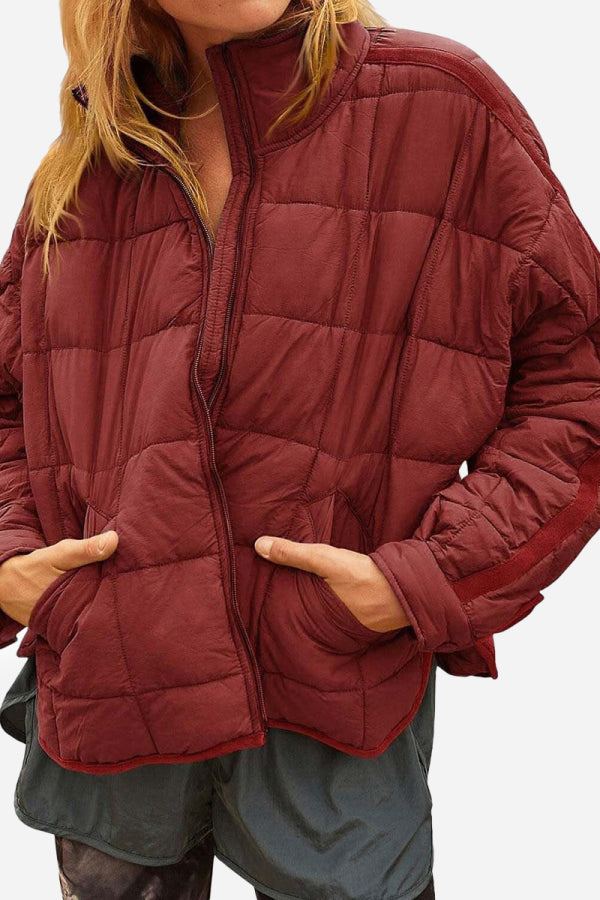 Woman wearing lightweight puffer travel jacket outdoors with backpack