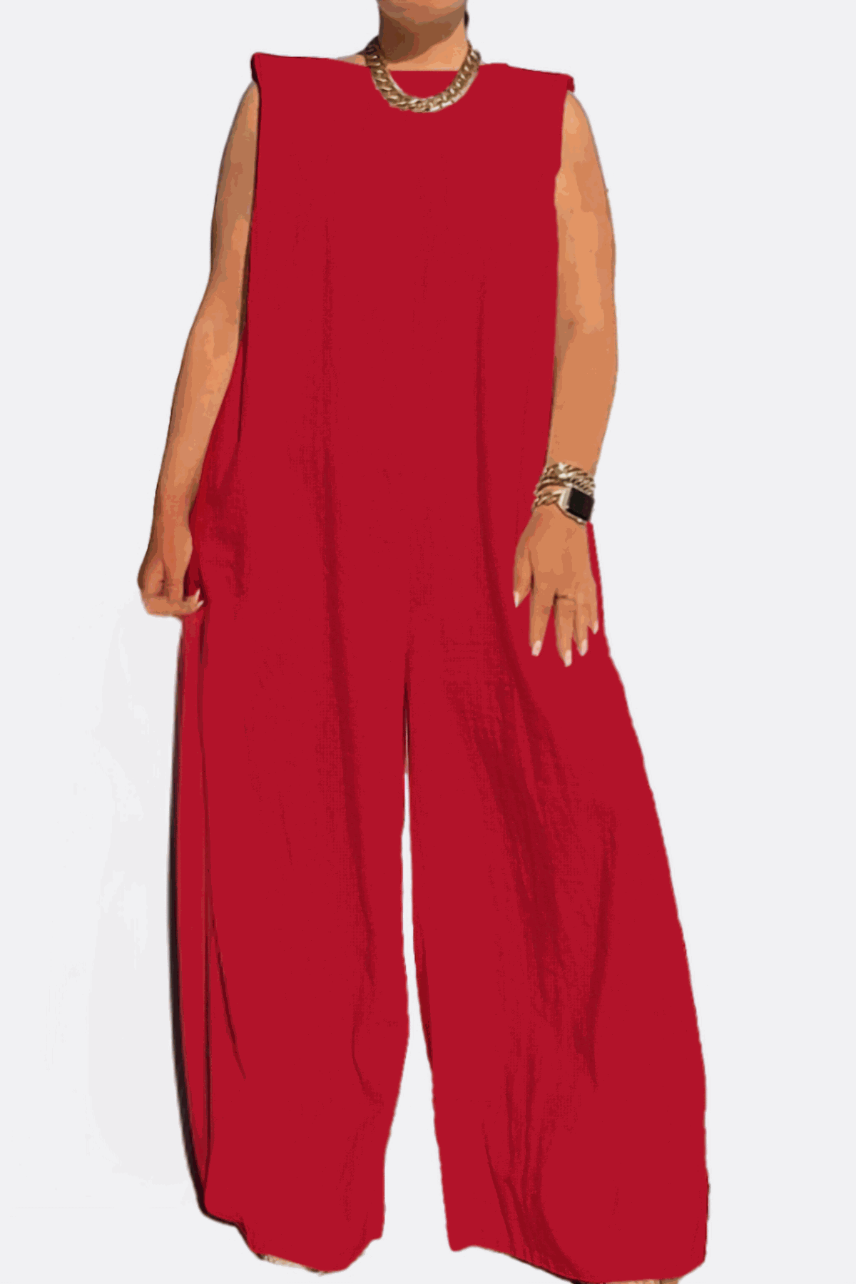 Red sleeveless wide-leg jumpsuit with sharp shoulders and long flowing legs, styled with a chunky necklace and bracelet.