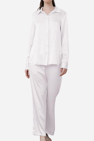 Woman wearing classic white Mulberry silk sleepwear set with long sleeves and full-length pants