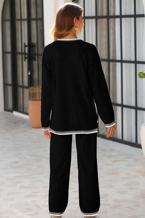 Woman wearing black Chic Contrast Stitch travel set with white contrast stitching, standing indoors facing away.