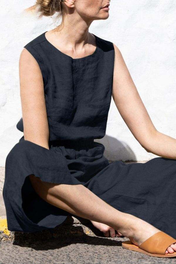 Woman wearing black pure cotton sleeveless minimal confidence two-piece set sitting outdoors
