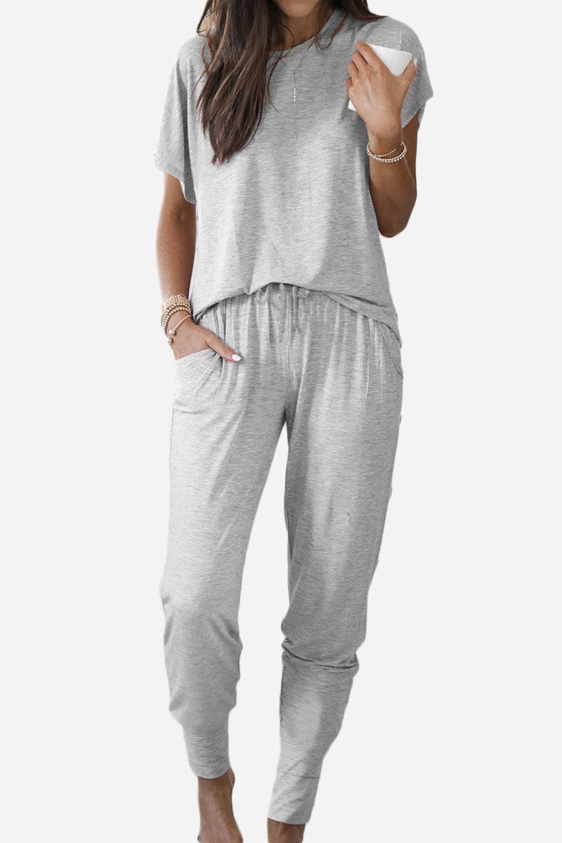 Woman wearing ultra-soft two-piece gray loungewear set with batwing sleeves and jogger pants with pockets