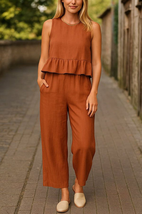 woman wearing rust-colored sleeveless linen-like feel set with wide-leg pants and ruffle top outdoors
