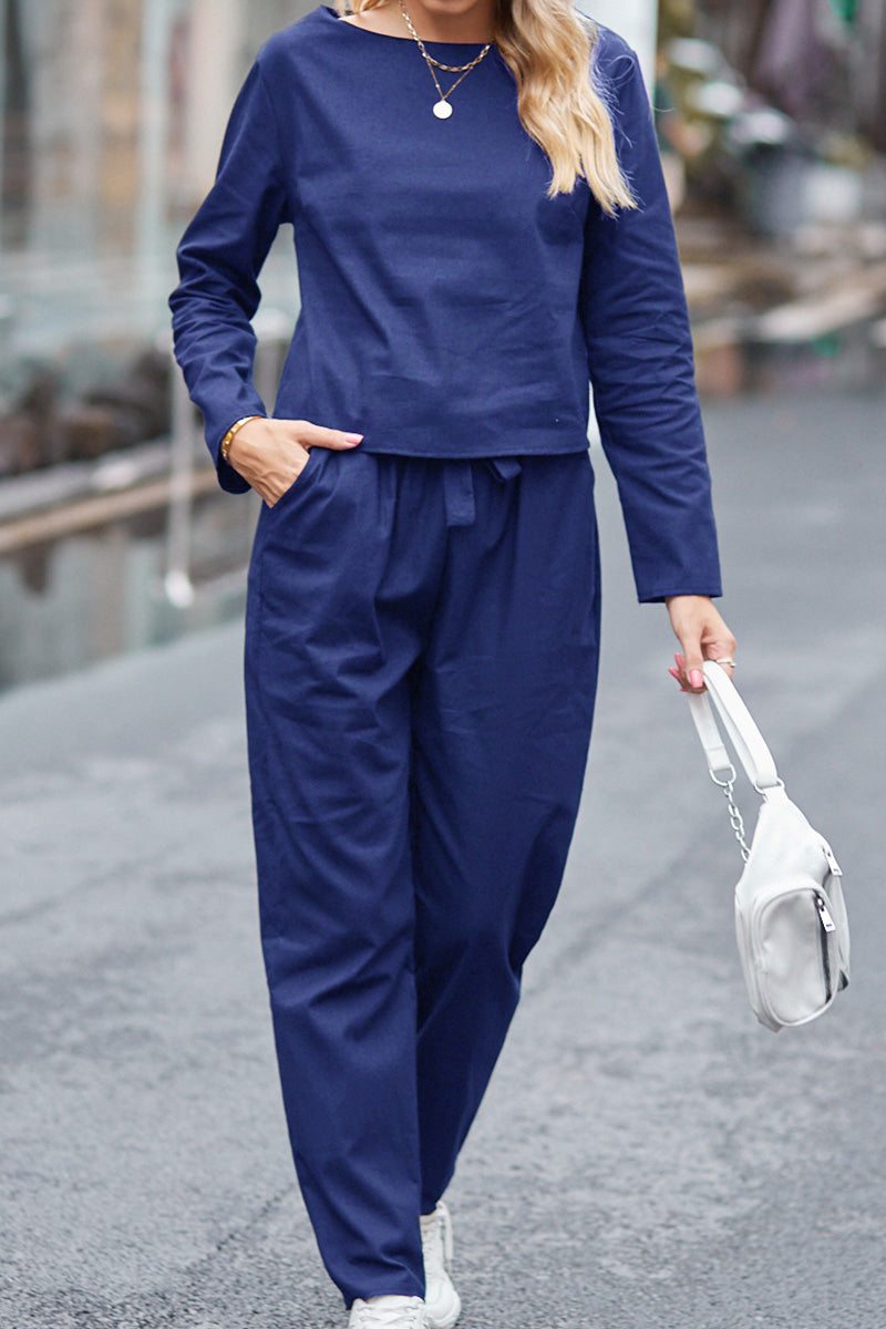 woman wearing navy blue casual chic duo relaxed shirt and trousers two-piece set walking outdoors with white purse