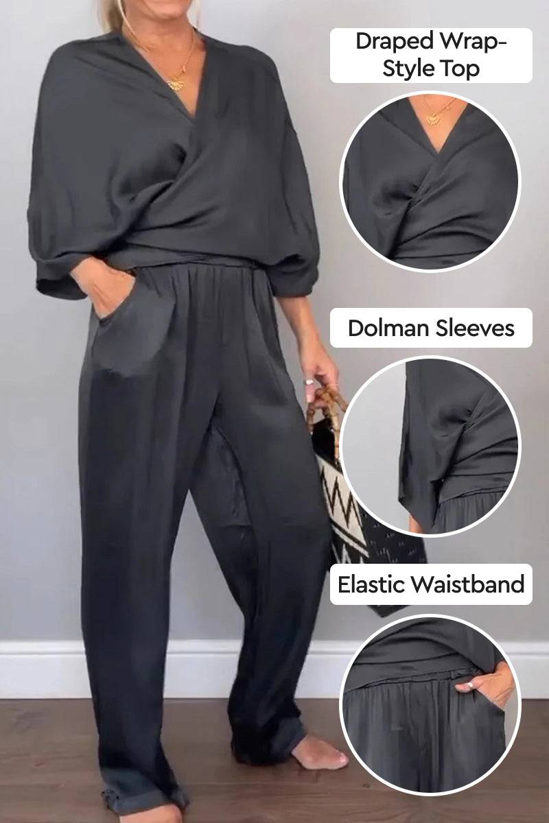 Black satin wrap lounge two-piece set with draped V-neck top, dolman sleeves, and elastic waistband pants for all-day comfort