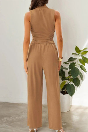 Back view of woman wearing brown Stroll & Hangout Ribbed Knit two-piece set with sleeveless top and wide-leg pants indoors near plant