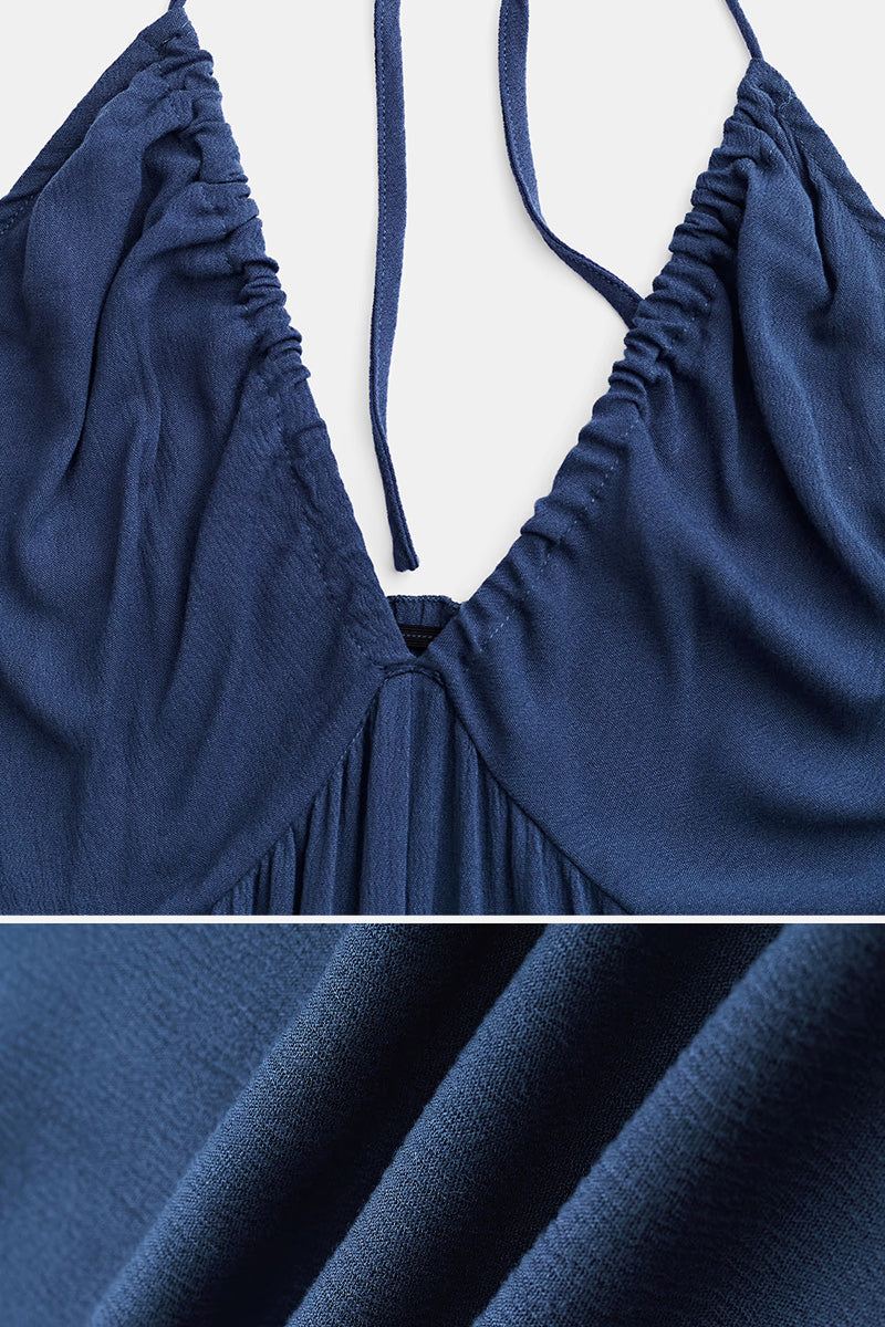 Close-up of navy blue Sunshine On Sand halter-neck jumpsuit fabric and ruched neckline detail