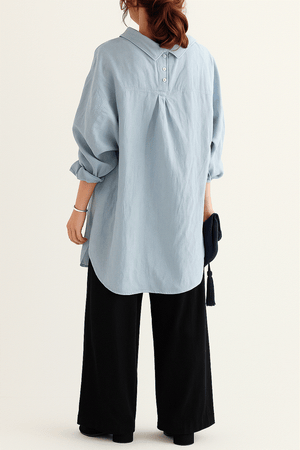 Woman wearing a light blue linen-cotton blend oversized shirt and black high-waist palazzo pants from the Linen Breeze Set.