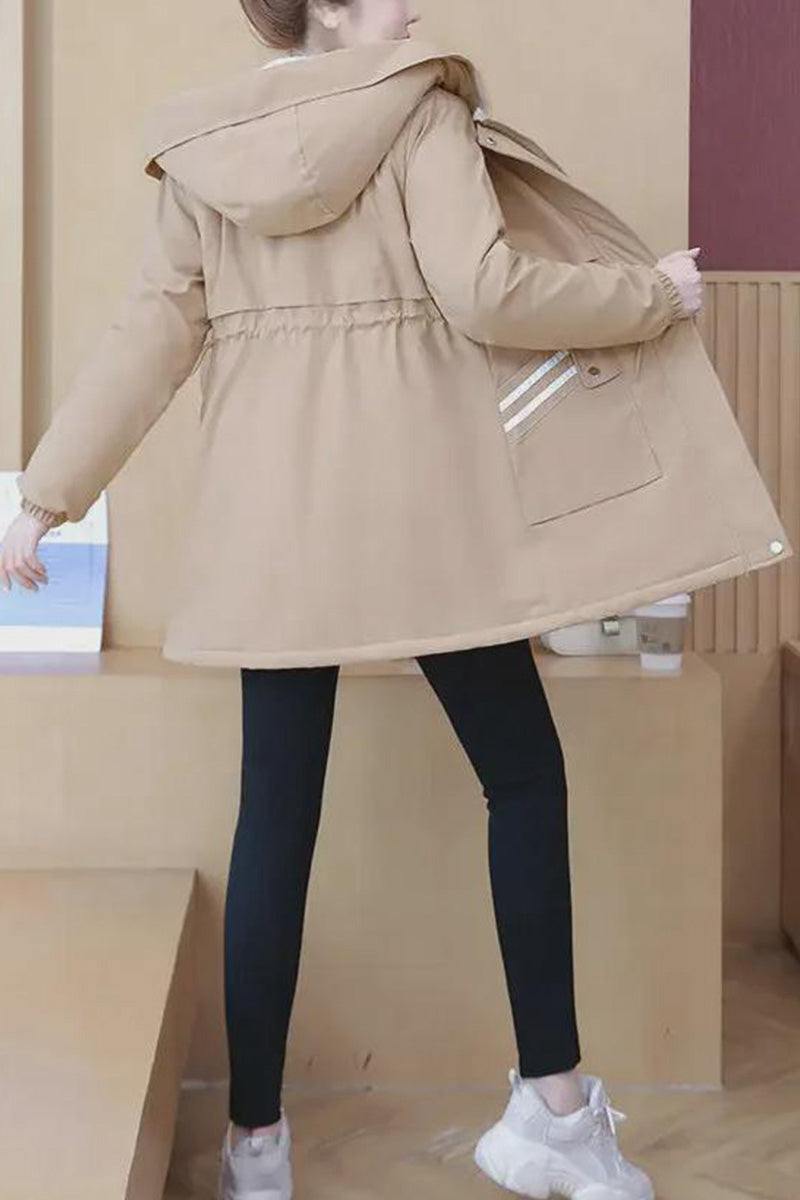 Back view of a woman wearing a beige Cityscape Comfort Hooded Windbreaker with a plush interior and mid-length fit paired with black leggings and white sneakers.