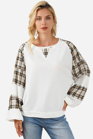 Waffle knit sweatshirt with plaid sleeves and relaxed drop shoulder fit on female model