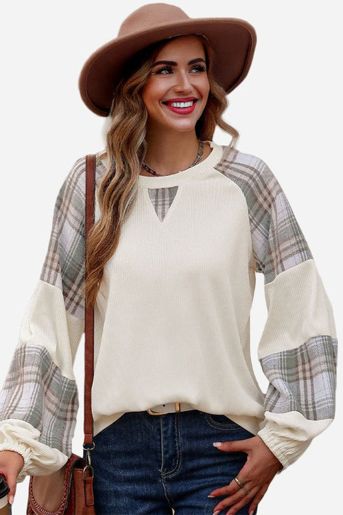 Waffle knit sweatshirt with plaid sleeves and relaxed fit, styled with jeans and a hat