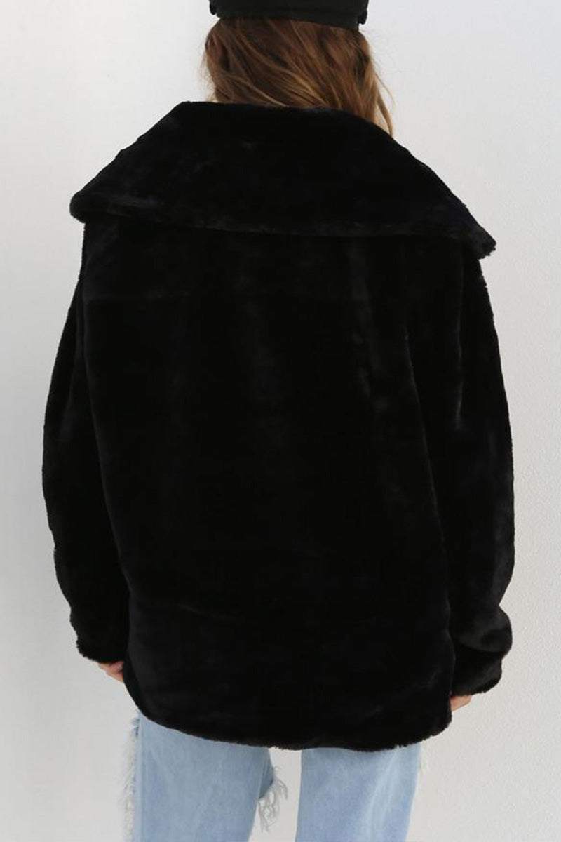 Back view of a black open front oversized faux fur jacket with a draped shawl collar and relaxed fit worn with light blue jeans