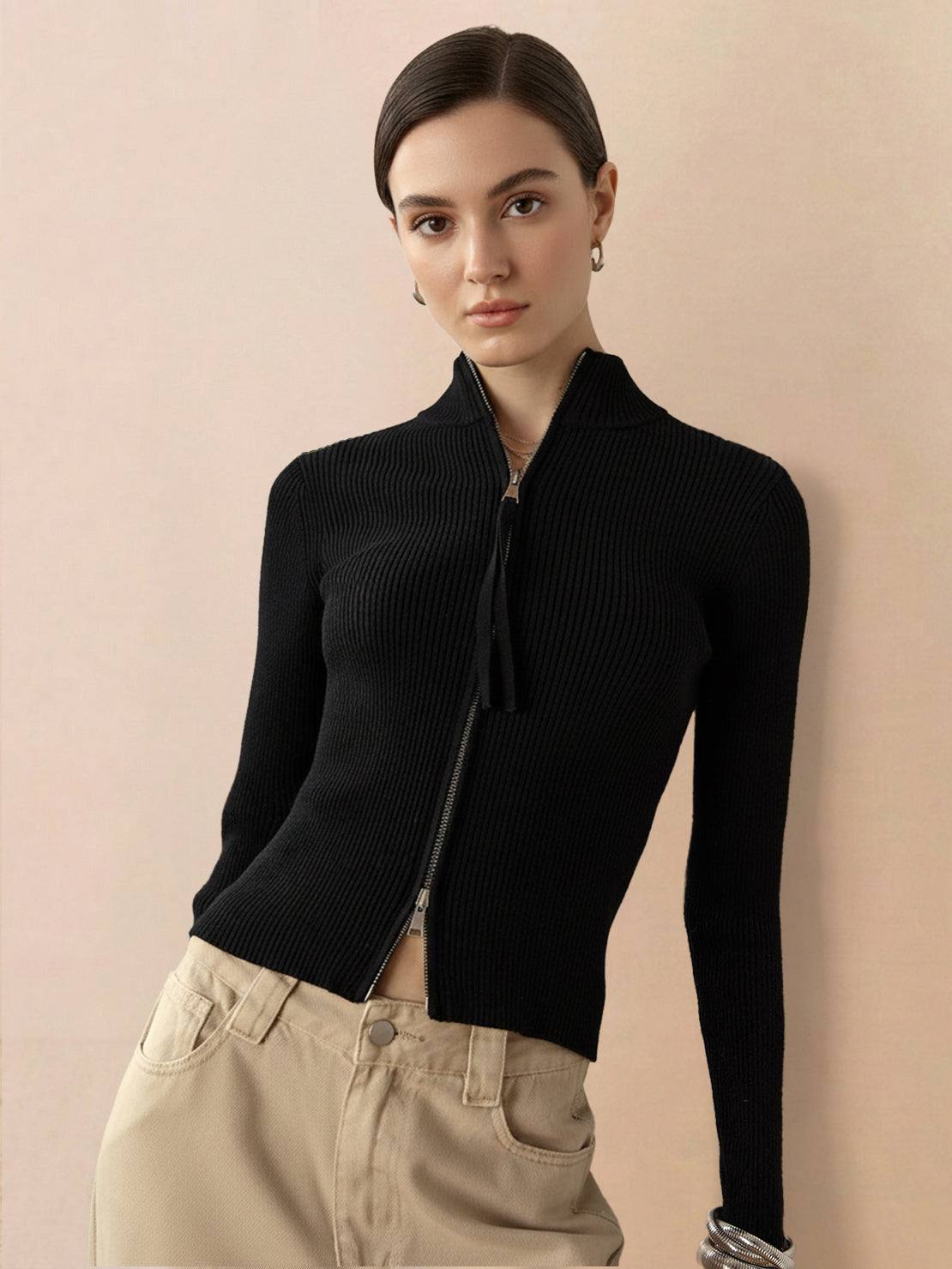 Woman wearing a slim-fit ribbed zip-up knit cardigan jacket with high neckline and long sleeves