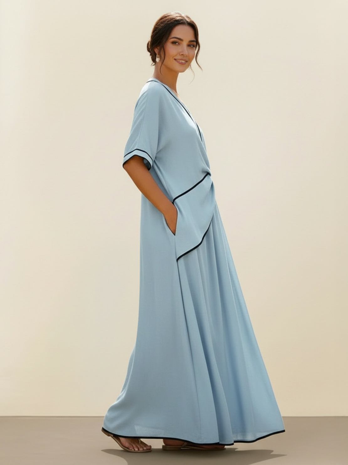 Woman wearing a knot-waist maxi dress with V-neckline and flowing skirt