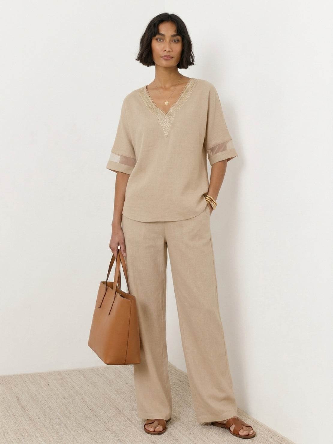 Mature woman wearing lightweight linen top with V-neck, short sleeves, and three-button front detail
