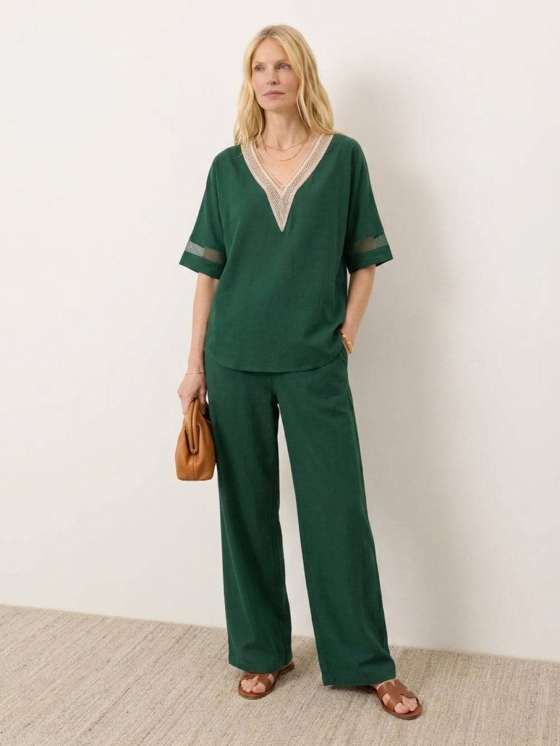 Mature woman wearing lightweight 100% linen top with V-neck, short sleeves, and three-button front detail in relaxed boxy shape