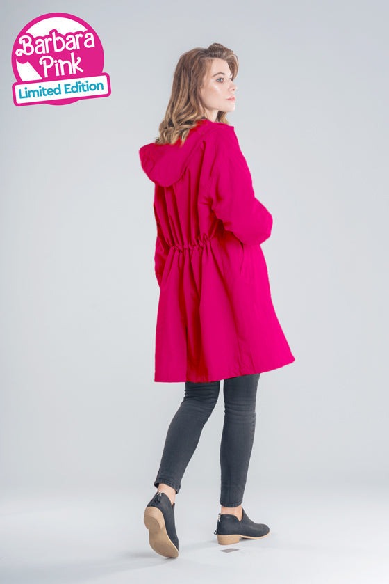 Woman wearing oversized red water-resistant windbreaker with hood and elastic waist