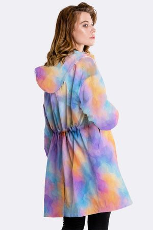 Colorful water-resistant windbreaker jacket with oversized fit and hood worn by woman from back side
