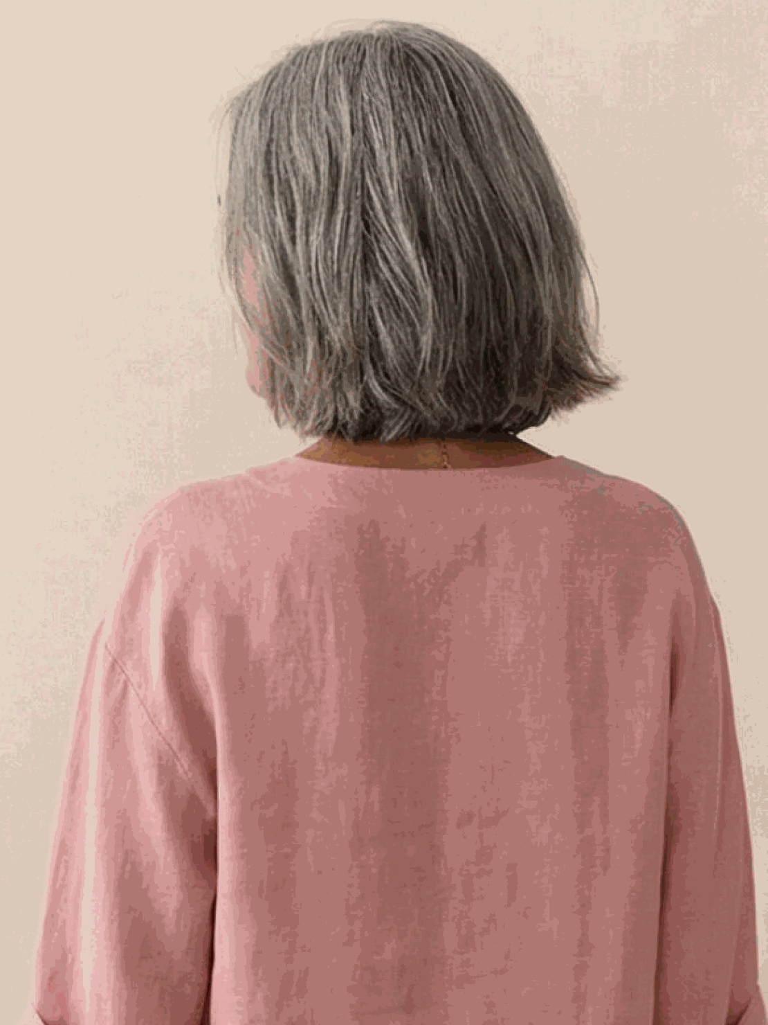 woman wearing pure linen age-defying button detail shirt sitting on wooden bench outdoors