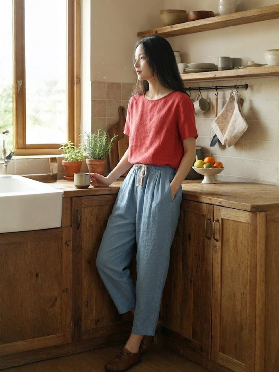 woman wearing orange relaxed fit straight pants walking outdoors in city environment