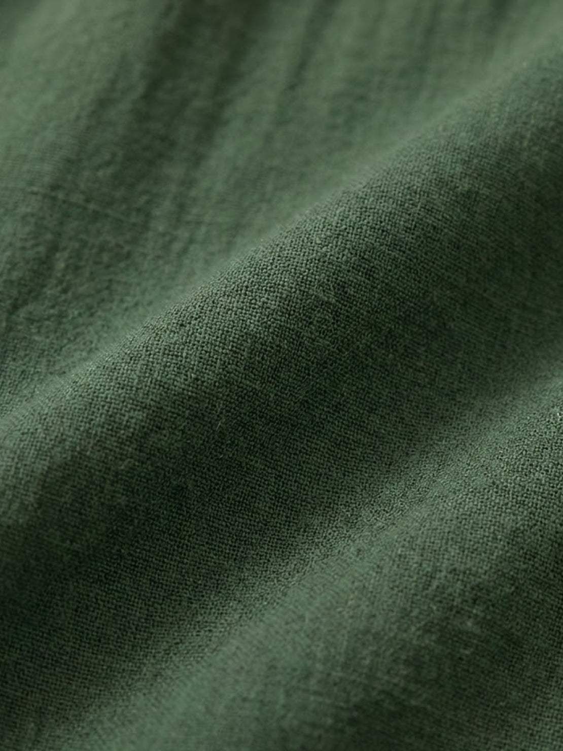 Woman wearing capped-sleeve voluminous pleated midi dress with flowing skirt and pockets