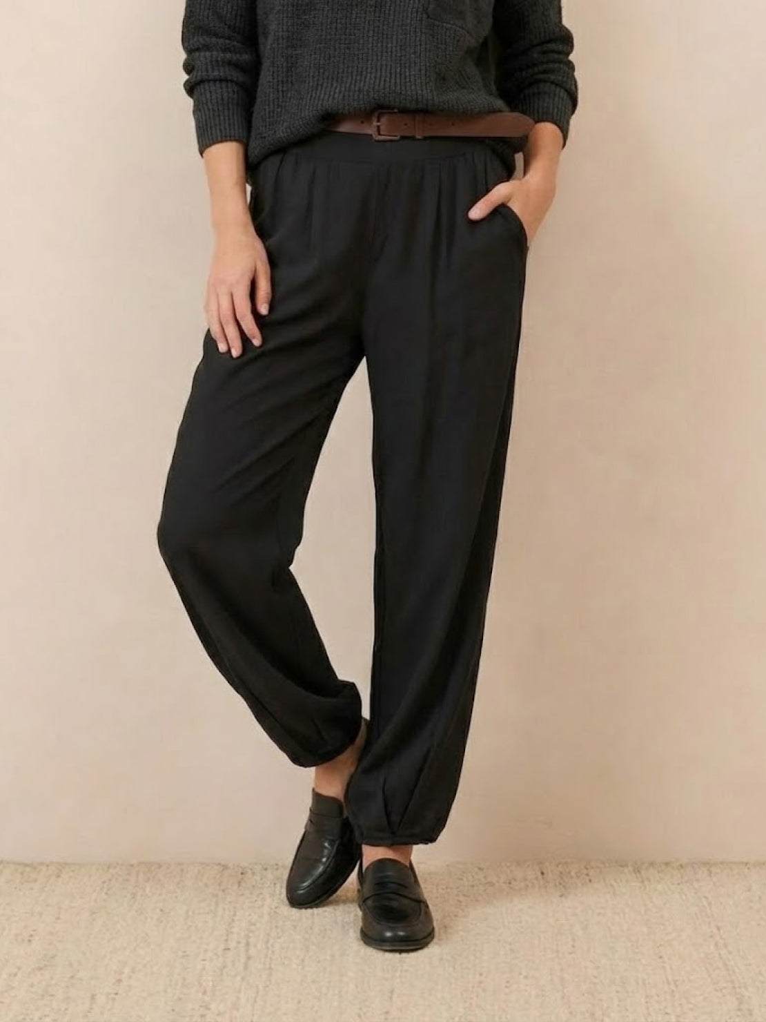 European Minimalism relaxed black knit trousers styled with casual sweater and loafers