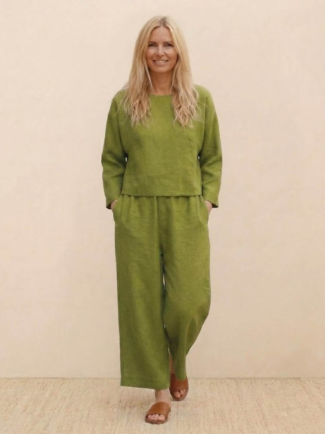 Woman wearing loose solid color green two-piece set with pullover and wide-leg pants