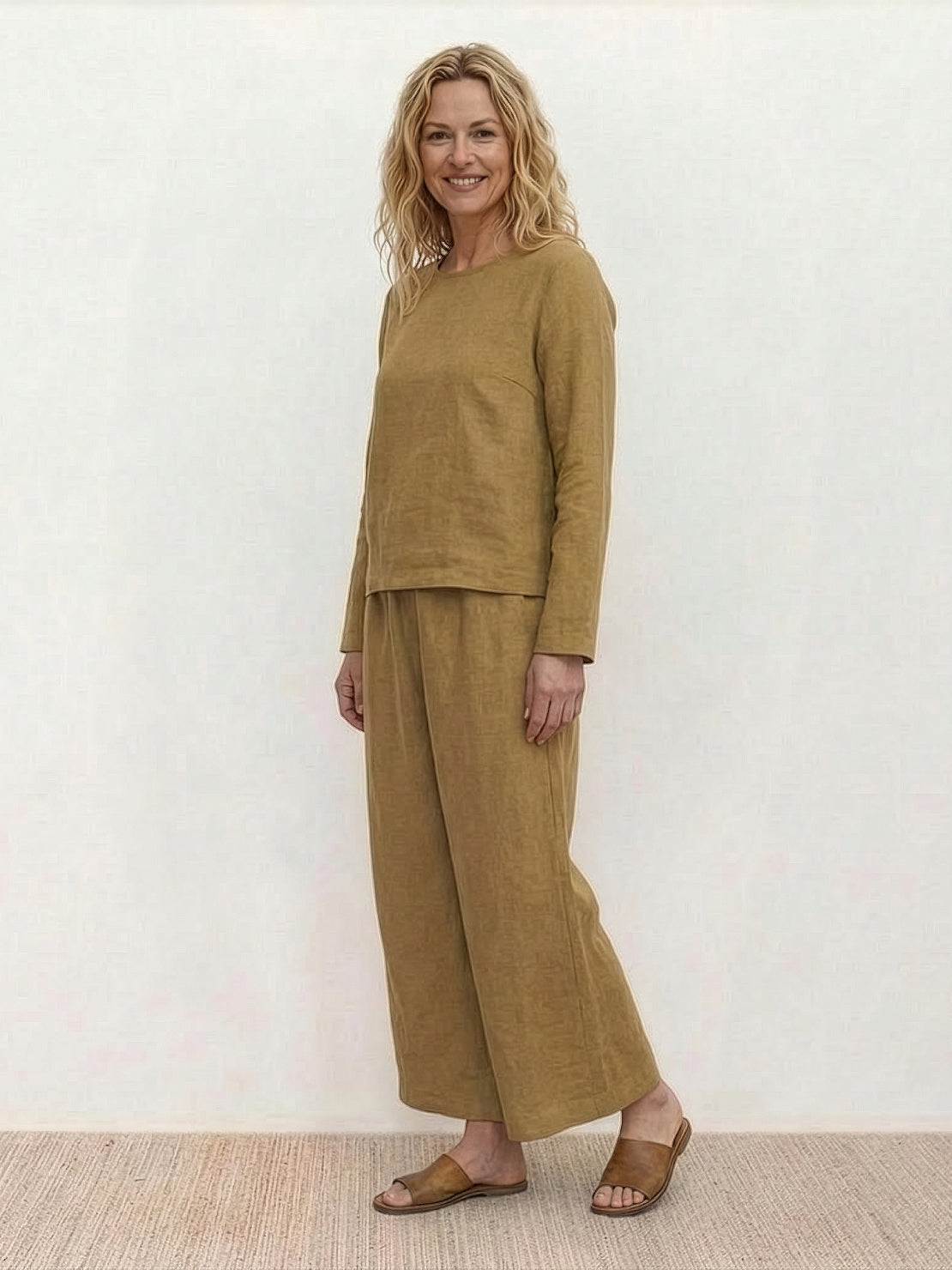 woman wearing loose solid color two-piece set with round-neck pullover and wide-leg pants standing outdoors