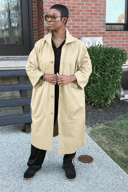 One size fits all oversized water resistant windbreaker jacket in beige with snap-button closure and attached hood, styled for casual outdoor wear.