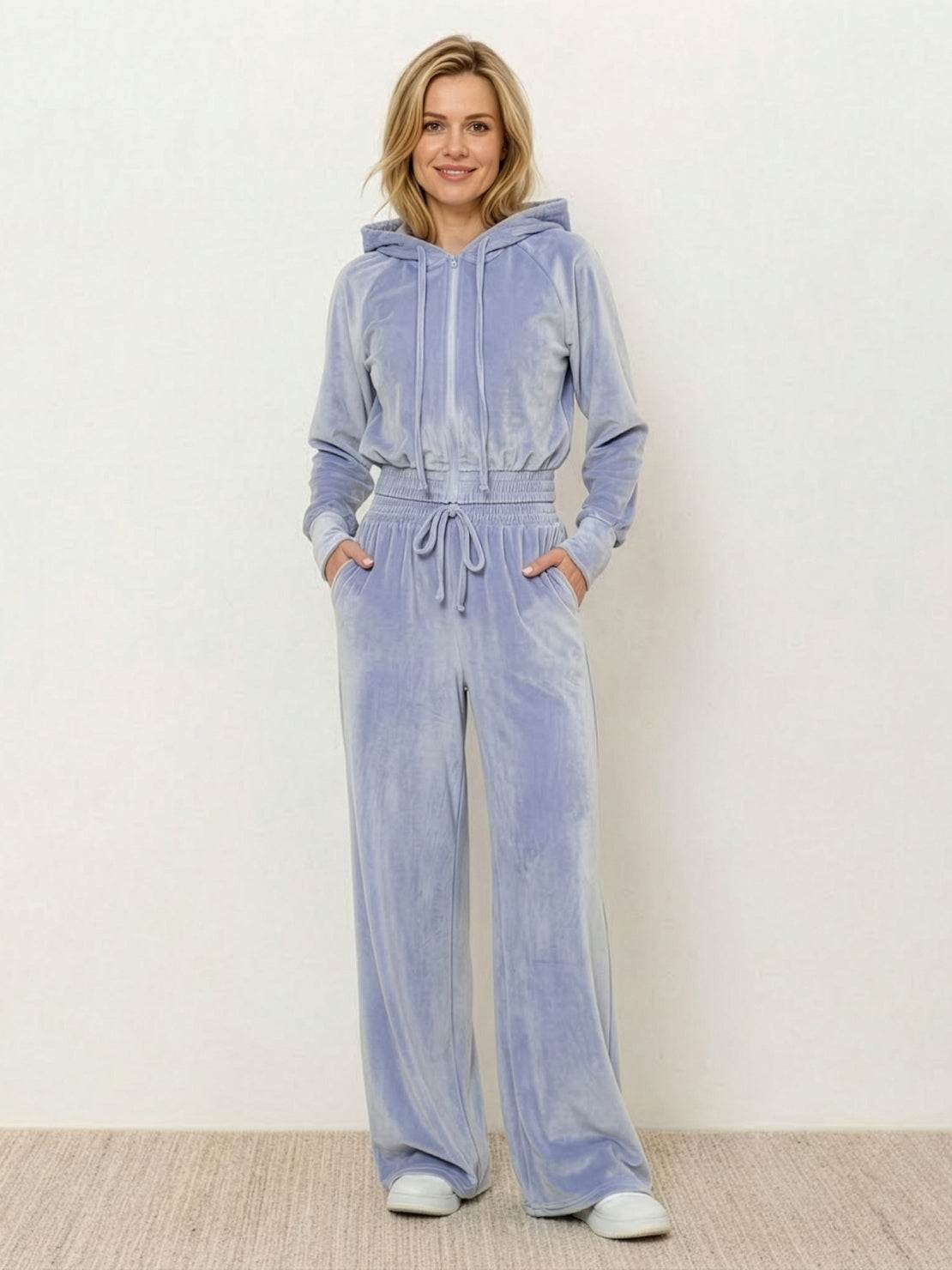 Model wearing modern cropped velour tracksuit set with high-waist pants in vibrant color