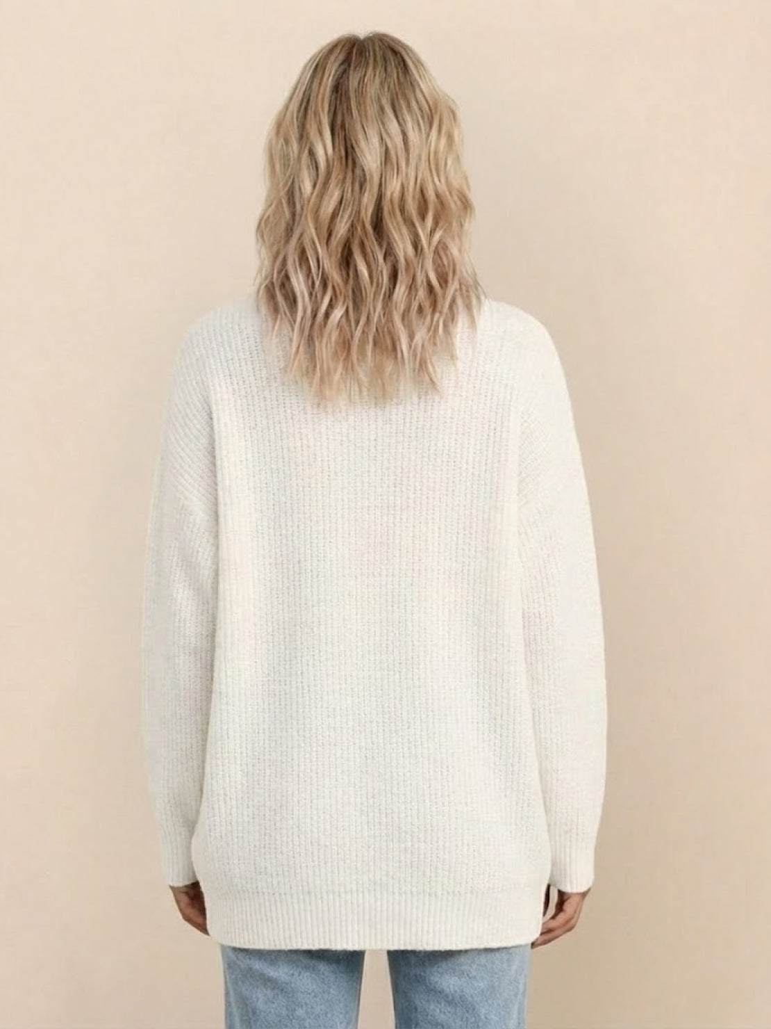 Relaxed fit oversized white knit cardigan worn by woman shown from the back