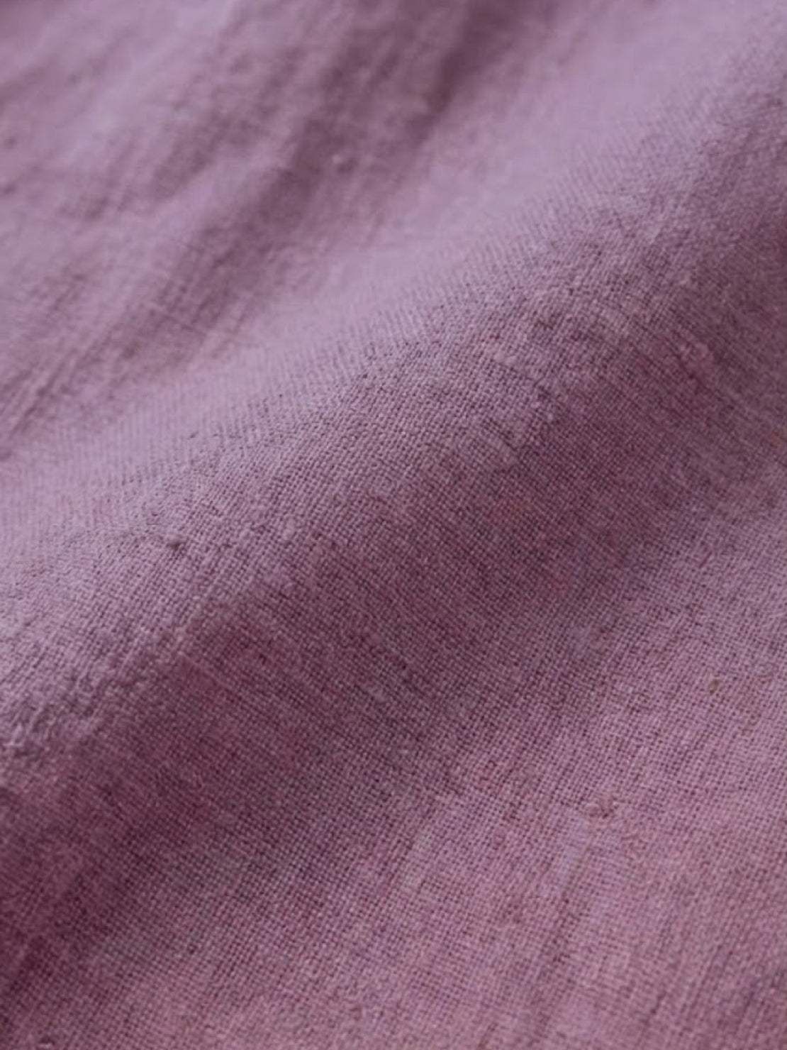 Close-up of relaxed loose breathable linen fabric in soft purple color