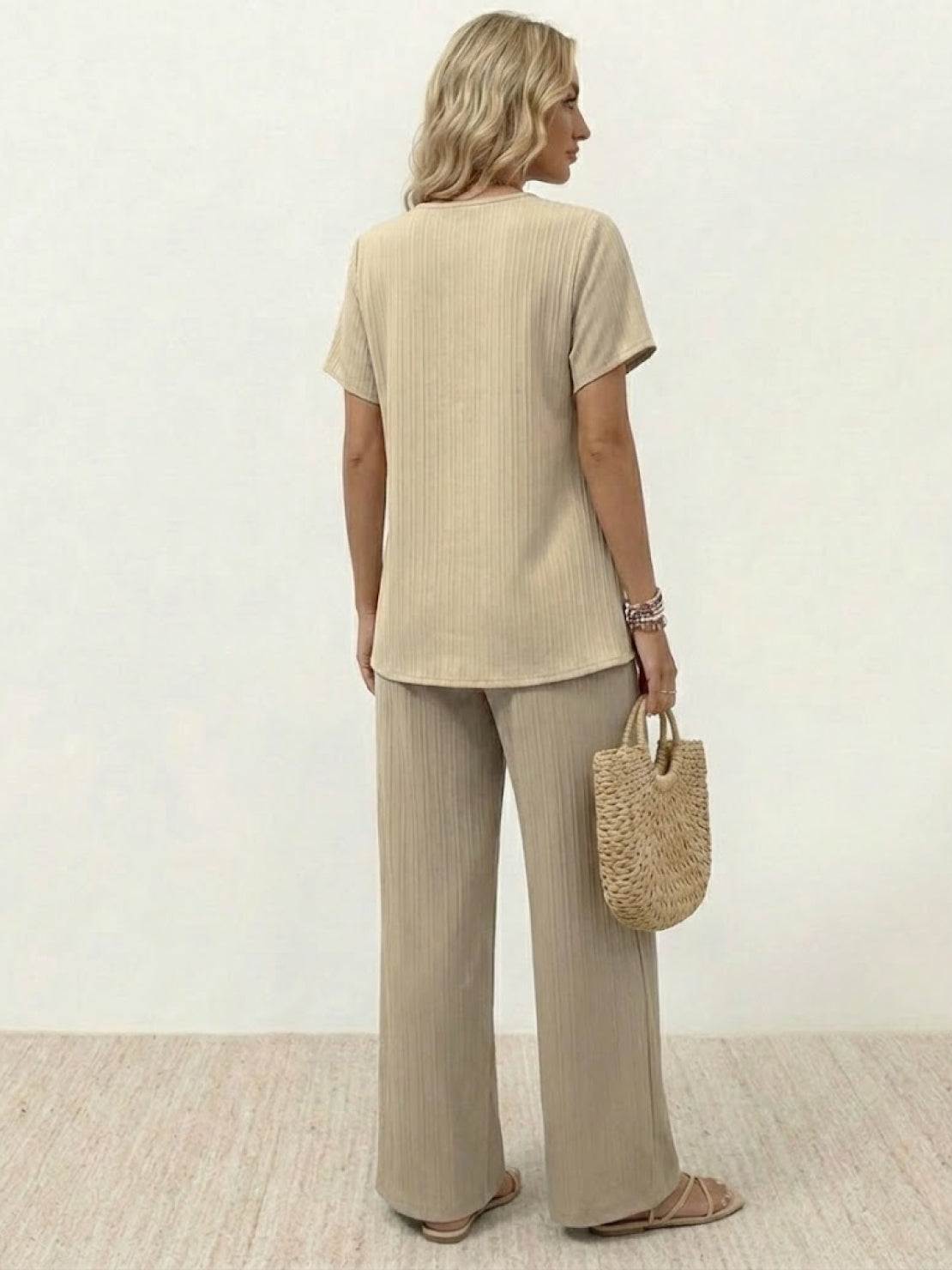 Woman wearing textured elegance two-piece set with asymmetrical top and wide-leg pants in neutral tone