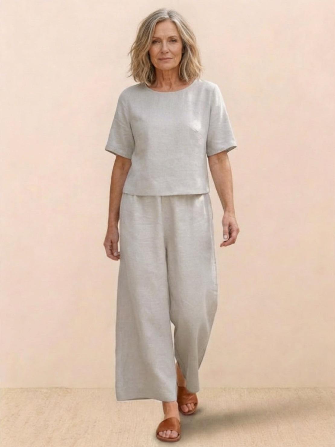 Woman wearing a loose fit co-ord set with a soft-tailored top and wide-leg bottoms in solid color
