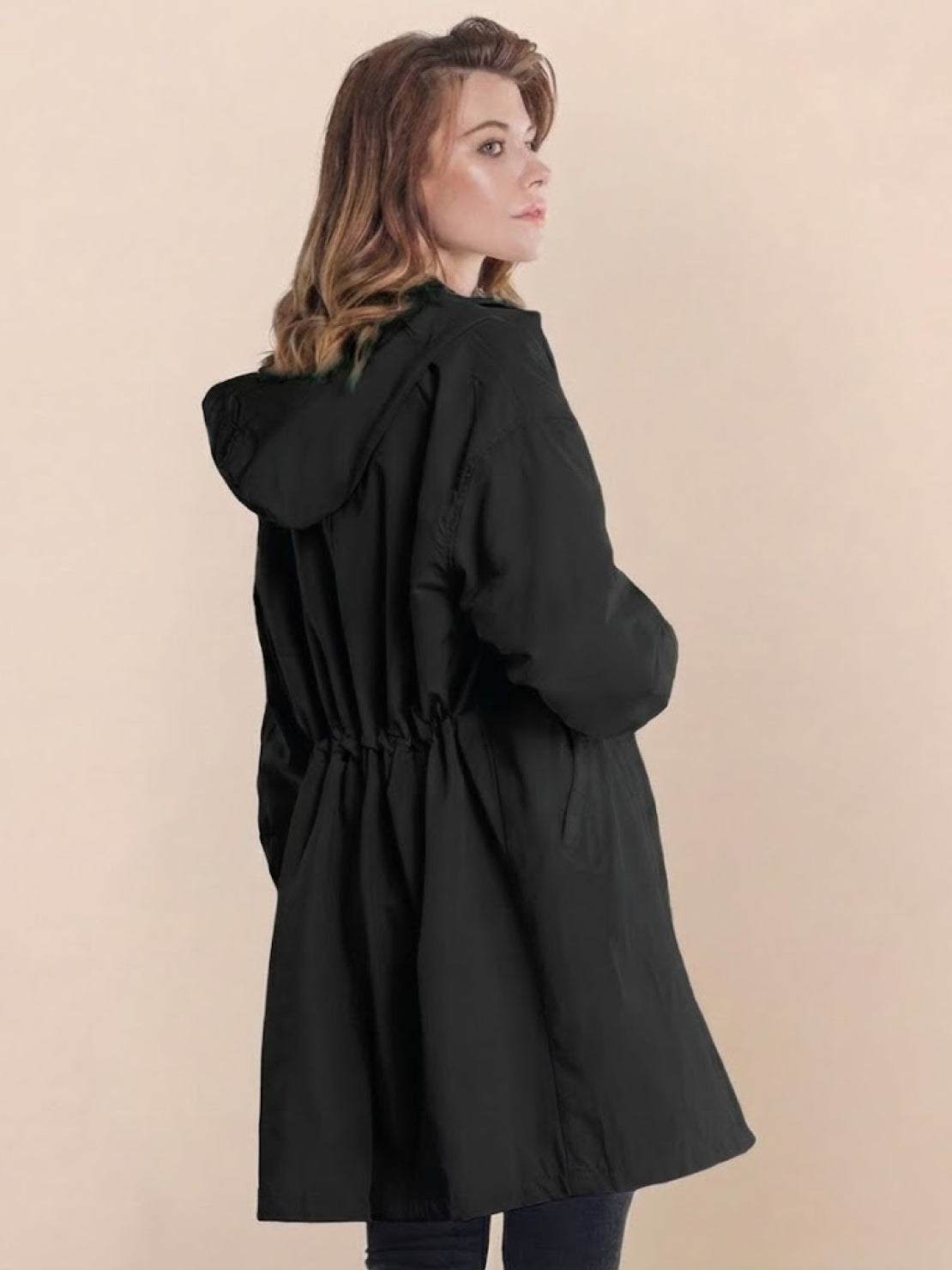 Woman wearing black oversized Rain Couture Windbreaker with hood, back view, water-resistant jacket