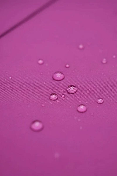 Close-up of water-repellent fabric with water droplets on purple surface for raincoat