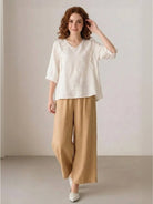 Woman wearing 100% cotton linen blend golden hour set with embroidered V-neck top and wide-leg trousers