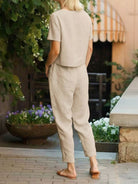 Woman wearing relaxed cotton linen set with short-sleeve top and straight-leg pants in monochrome tones