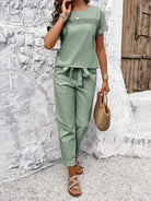 Woman wearing sage green 100% cotton total comfort two-piece travel outfit with short sleeves and drawstring pants.