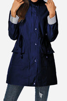 Women's navy hooded water resistant windbreaker jacket with striped cuffs and multiple pockets