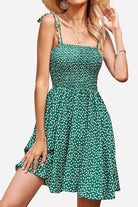 Green bohemian skater dress with white polka dots and sling knot straps, perfect summer vacation outfit.