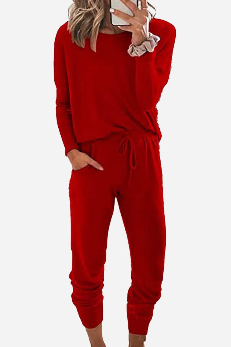 Woman wearing red Cozy Chic Two-Piece Sweatsuit set with long-sleeve top and high-waisted pants with pockets