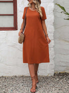 Radiant Escape Panelled Beach Dress in burnt orange, midi length, A-line skirt, round neck, soft polyester fabric, styled with woven handbag and sandals outdoors