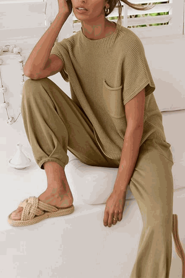 Woman wearing a beige Comfy Couture Knit Sweater two-piece set with knit pullover and high-waisted pants sitting indoors