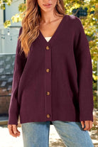 Relaxed fit oversized button down knitwear cardigan in dark purple worn with jeans outdoors