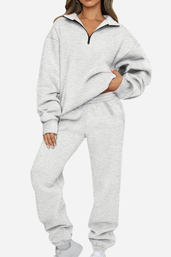 Woman wearing a light grey ultra-soft and comfy co-ord tracksuit set with a half-zip pullover and elastic cuffs.
